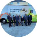 Group photo in front of a 'Destination Literacy' bus